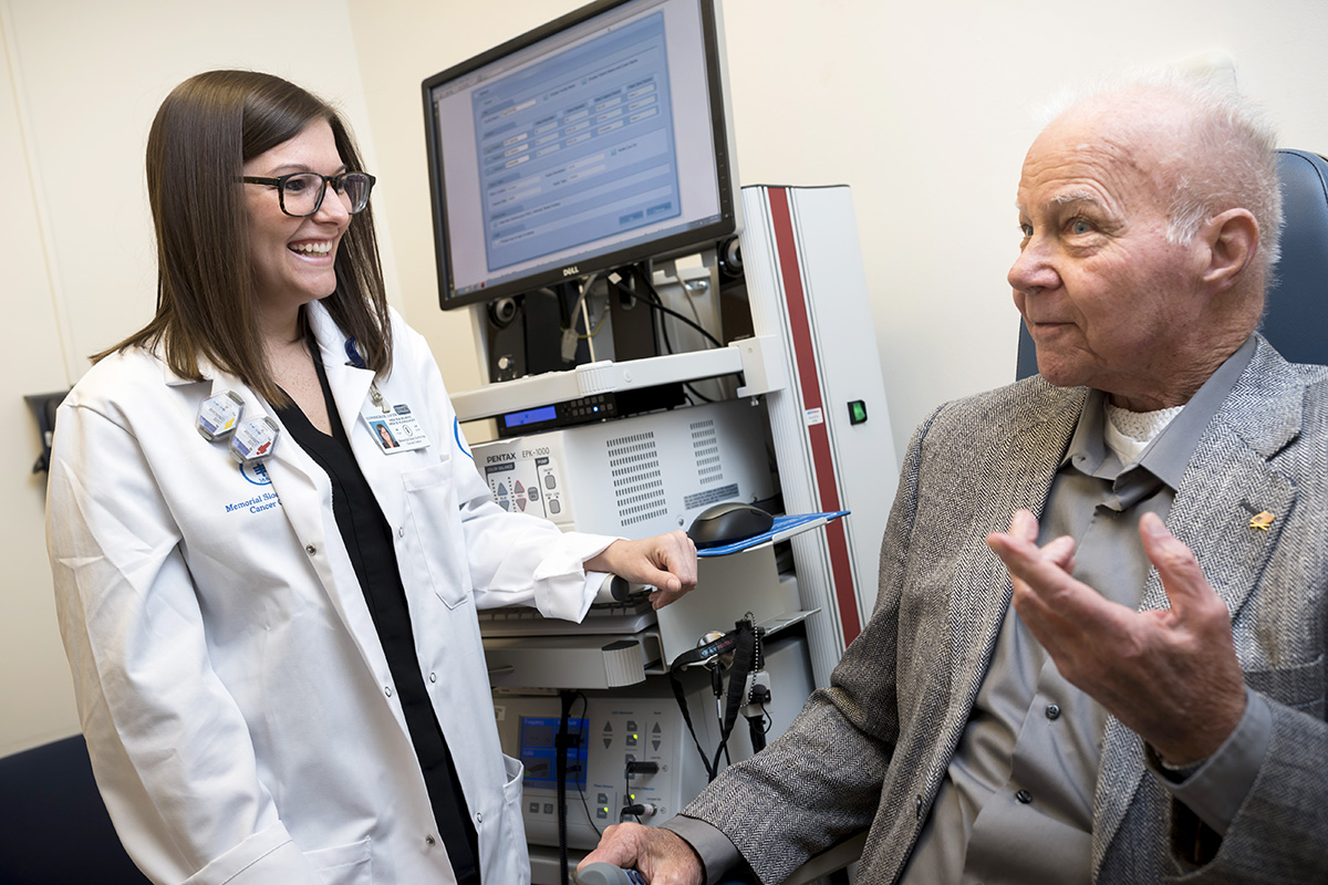 Memorial Sloan Kettering speech pathologist, Louise Cunningham, smiles at elderly male patient.