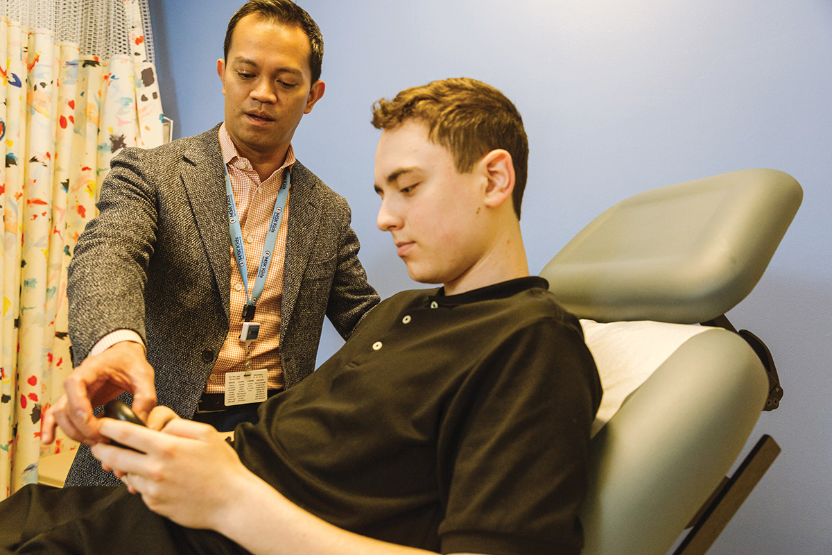 A doctor and teen patient in an exam room