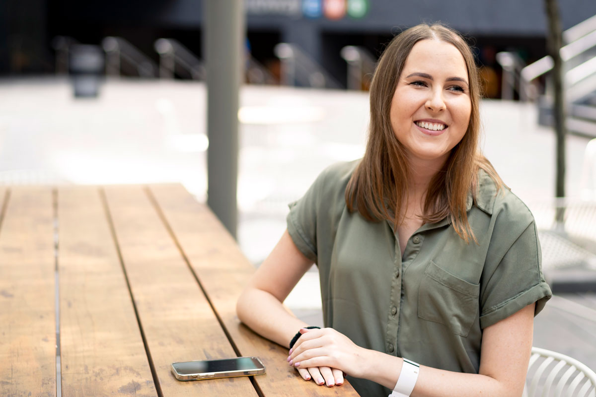 A young woman smiling with her cell phone